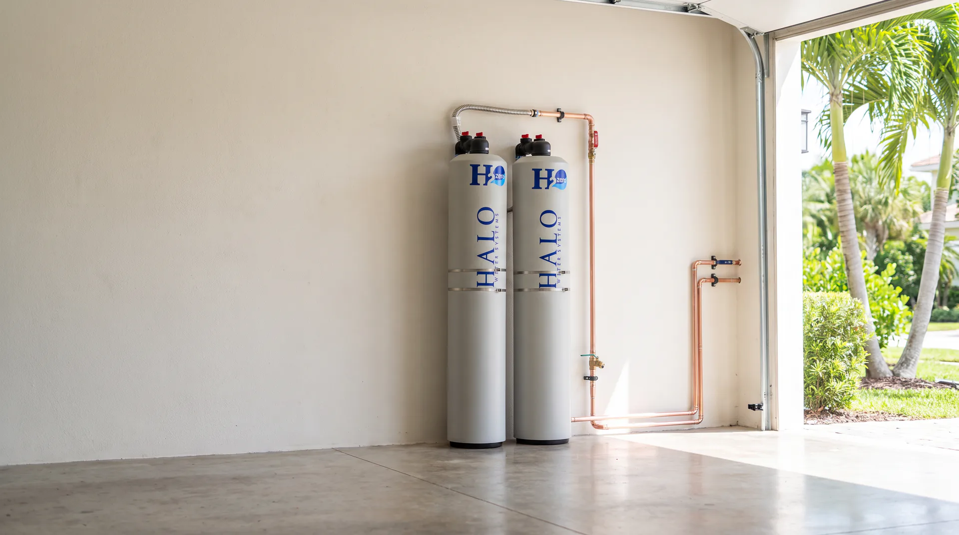 Whole-home water filtration system installed with clean copper piping in a South Florida garage